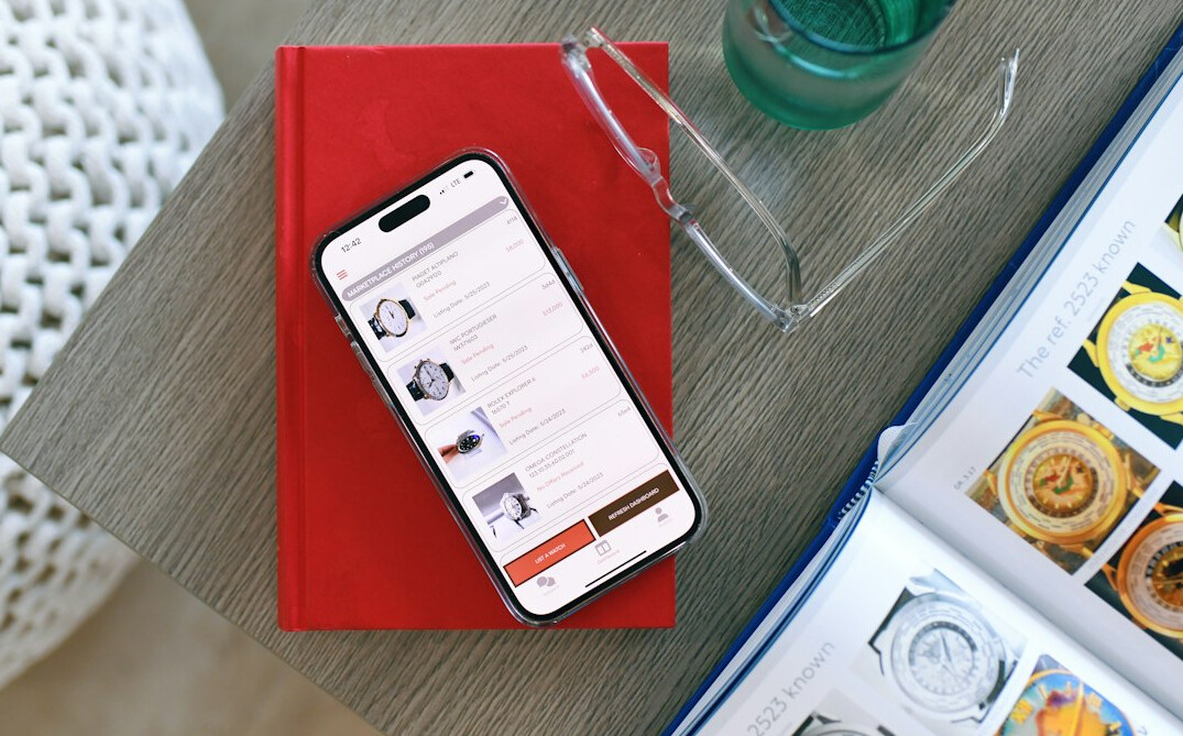 Smartphone displaying an email newsletter beside a notebook